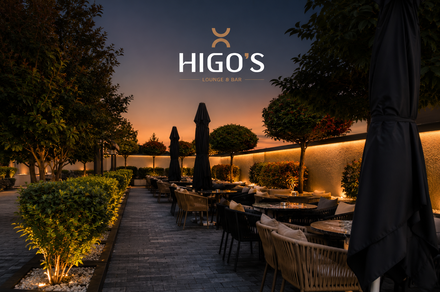 Terraca e HIGO'S Lounge Bar në mbrëmje, me ulëse dhe gjelbërim